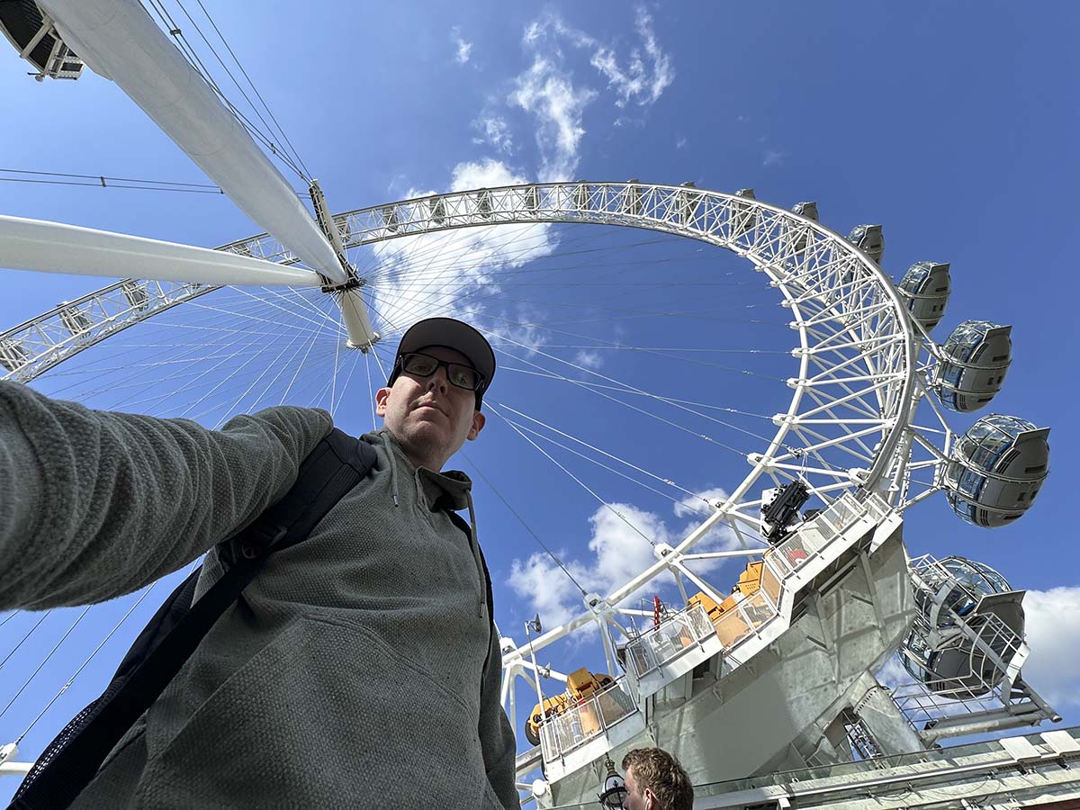 Scott Leazenby standing under the London Eye ferris wheel